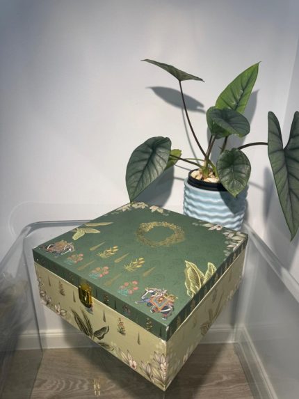 Green square 4-jar gift box with botanical art and small elephant motifs, gold latch