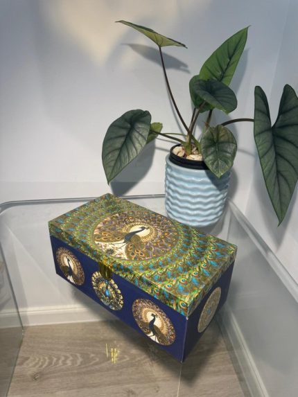 Deep blue rectangular 3-jar gift box with circular peacock artwork and gold clasp